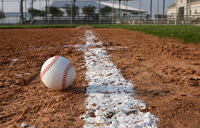 baseball laying on ground in baseball diamond chalk line